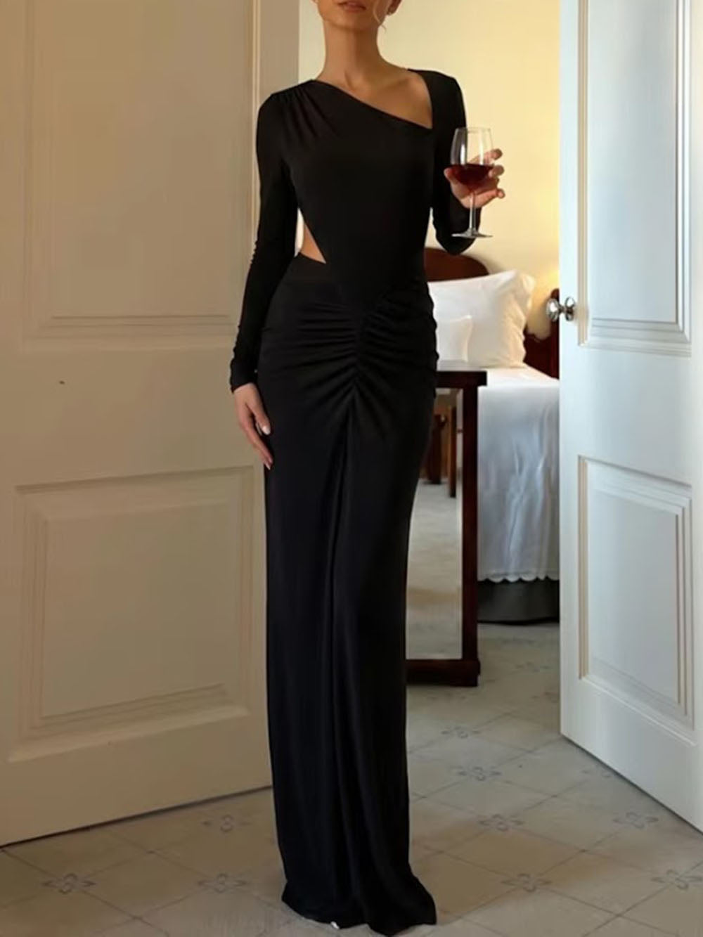 Model wearing the black asymmetric maxi dress with long sleeves, side cutout, and ruched hip
