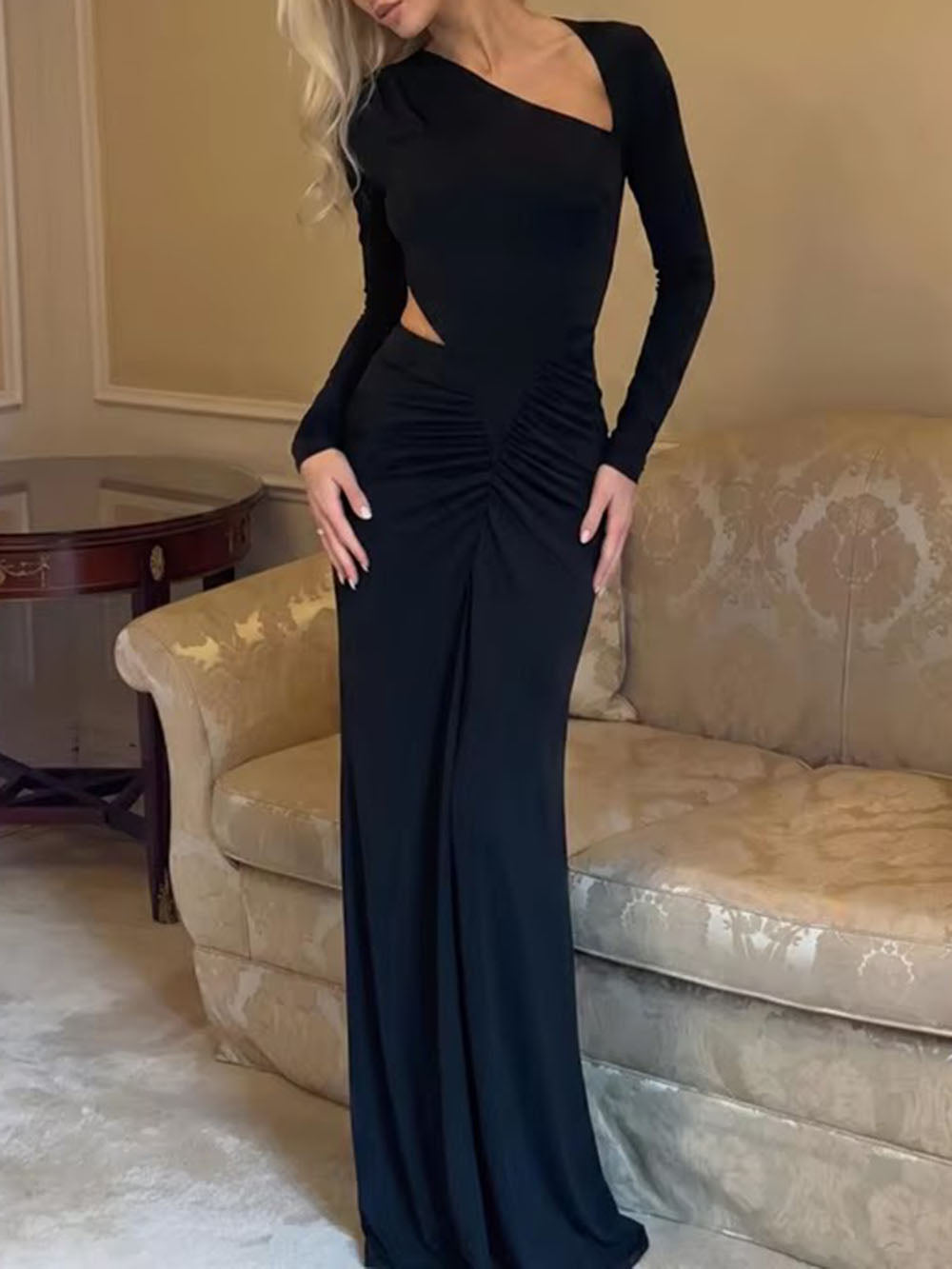 Three-quarter view of the black dress highlighting its asymmetric neckline and fitted silhouette