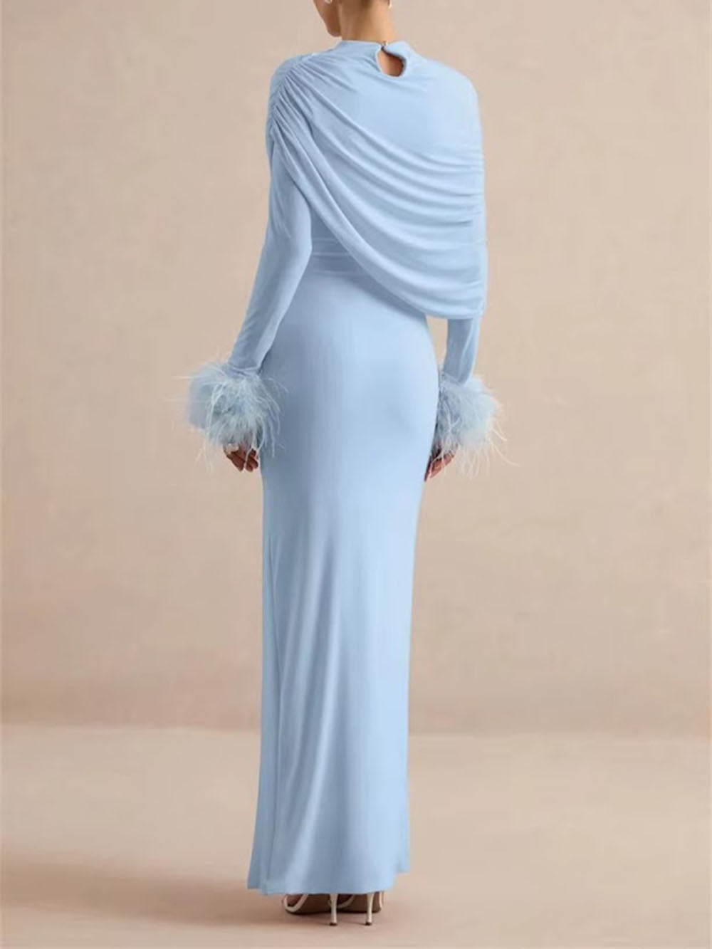 Back view of the powder blue maxi dress with draped shoulder panel and feather cuffs