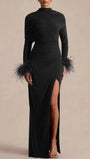 Front view of the black floor-length dress with long sleeves, feather cuffs, and thigh slit