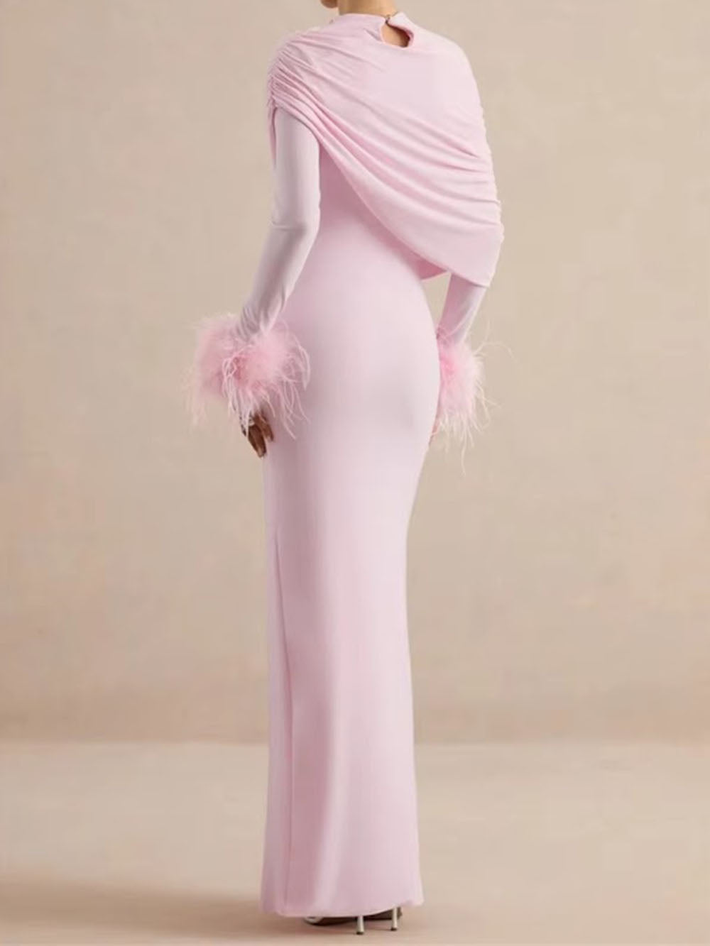 Back view of the blush pink dress showing the asymmetric draped shoulder and feather trim