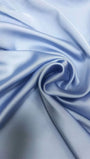 Close up of smooth powder blue fabric gathered into soft fluid folds