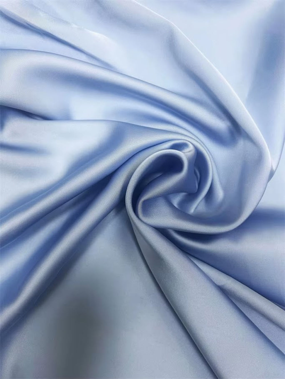 Close up of smooth powder blue fabric gathered into soft fluid folds
