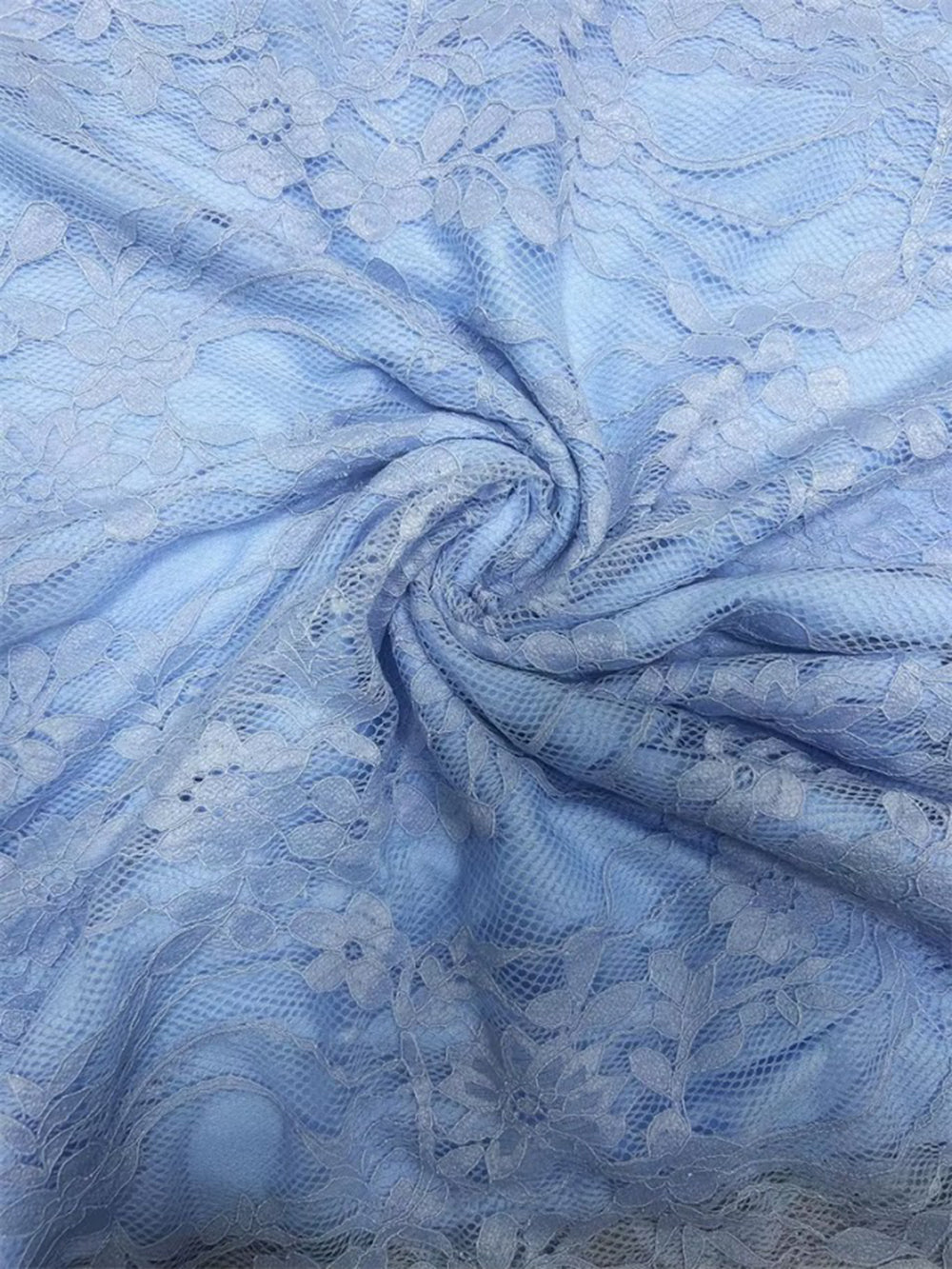 Close up of powder blue floral lace showing the delicate patterned texture