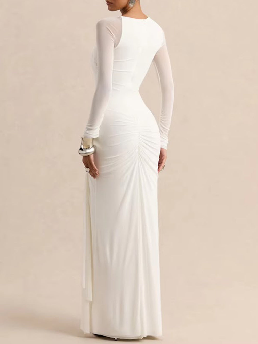 Back view of the white long-sleeve gown showing a fitted silhouette and gathered back hip detailing