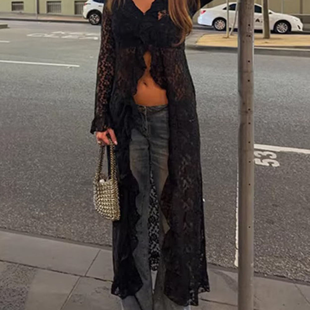 Model wearing the black longline lace blouse open over dark separates in a city setting