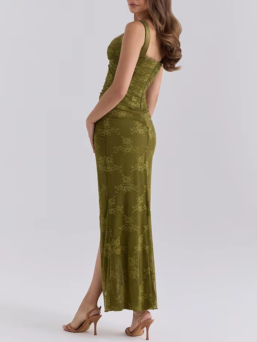 Angled side view of the green lace dress with a sculpted waist and high slit