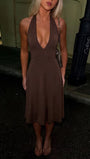 Model wearing the cocoa halter midi dress outdoors with plunging neckline and softly flared skirt