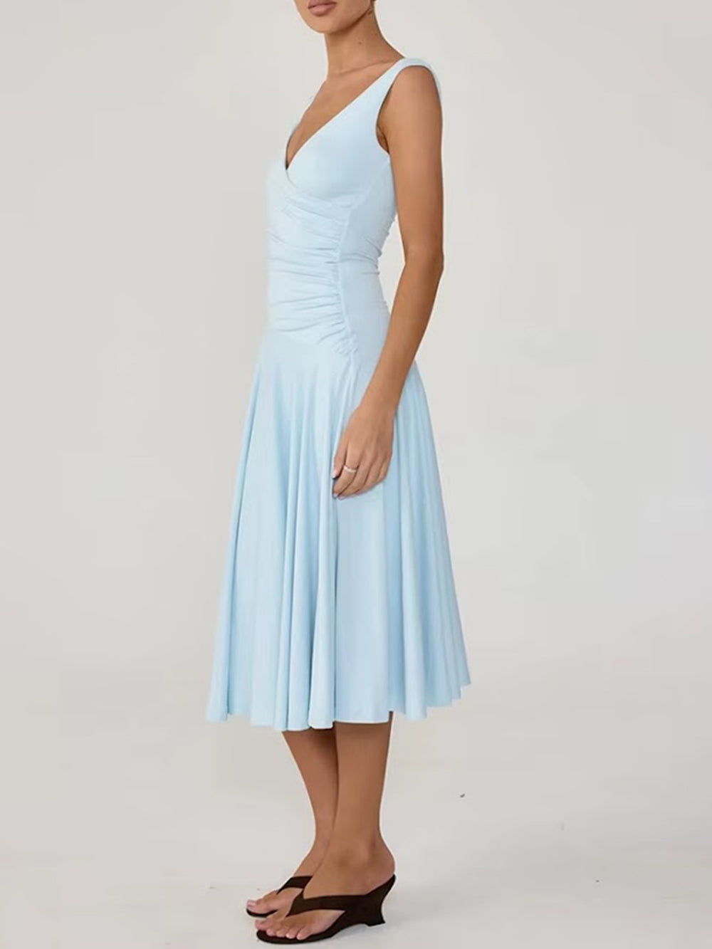 Angled view of the powder blue Noelle midi dress with a V neckline, ruched waist, and flared skirt