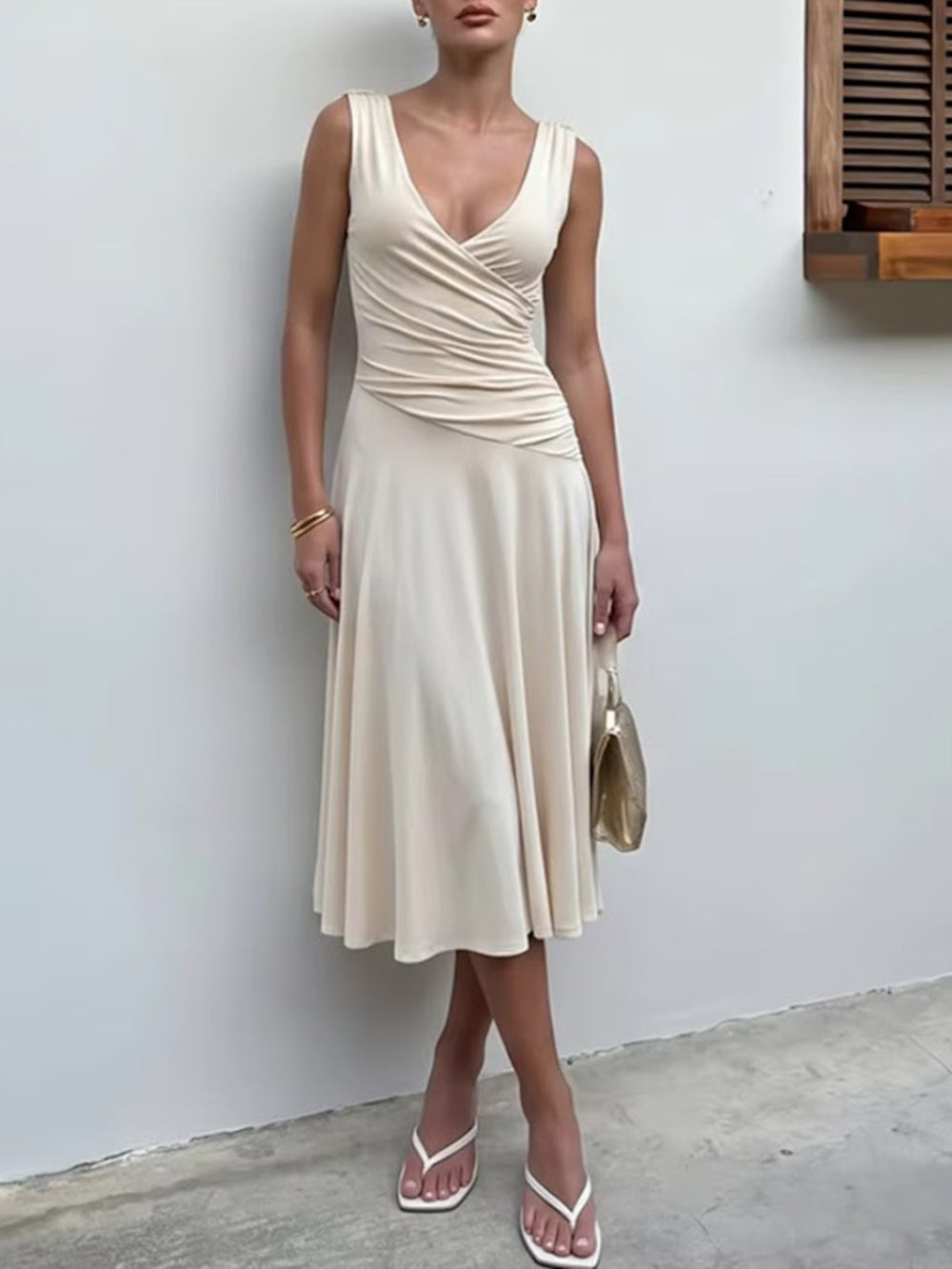 Model wearing the ivory midi dress with a crossover V neckline and softly draped flared skirt