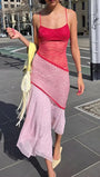 Model wearing the pink and red lace midi dress outdoors with an asymmetric flowing hem