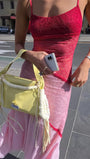Close up of the rose lace bodice and pale pink skirt while styled with a soft yellow handbag