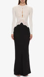 Front view of the monochrome dress showing white buttoned bodice, cutouts, and black fitted skirt