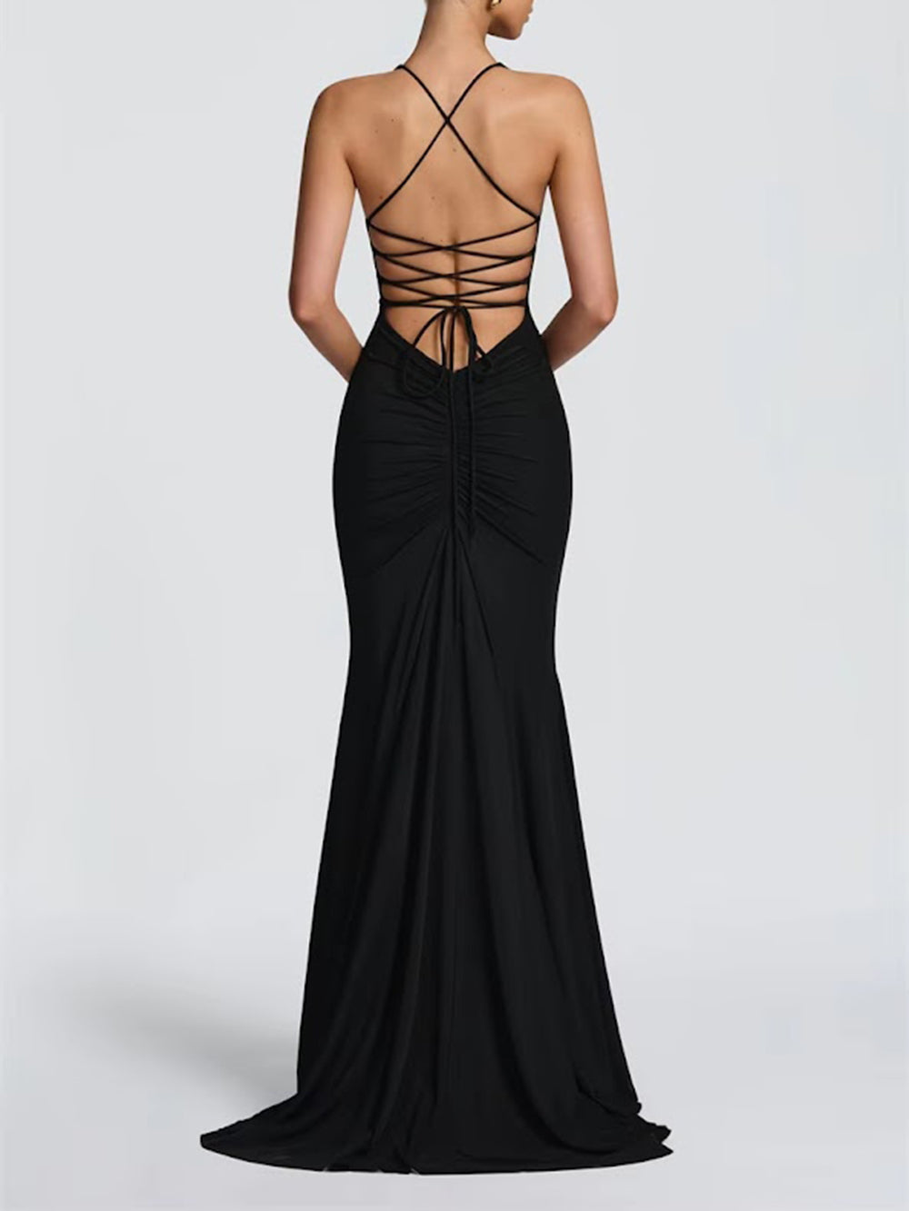 Back view of the black gown showing a dramatic lattice strap design and fitted skirt